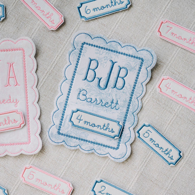 Embroidered name tags milestone cards with embroidered names and ages on a textured surface applique